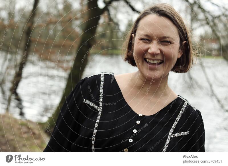 Portrait of a young, pregnant woman in the forest by the lake, laughing into the camera Woman Young woman To go for a walk Forest walk Relaxation Laughter Joy