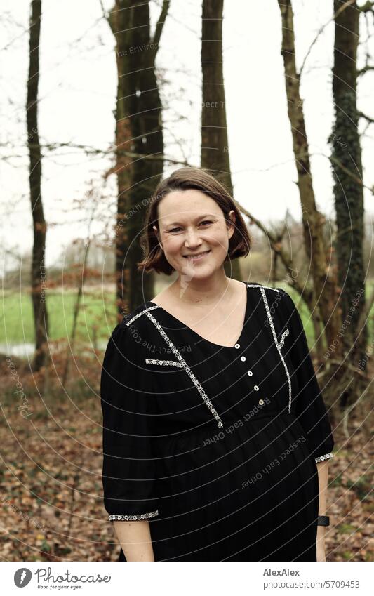 Portrait of a young, pregnant woman in the forest, she laughs into the camera Woman Young woman To go for a walk Forest walk Relaxation Laughter Joy fun