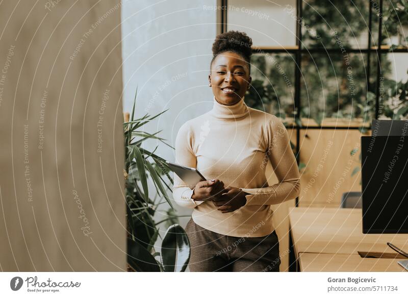 Young African American woman standing with digital tablet at the office african african ethnicity american black business business people businesswoman career