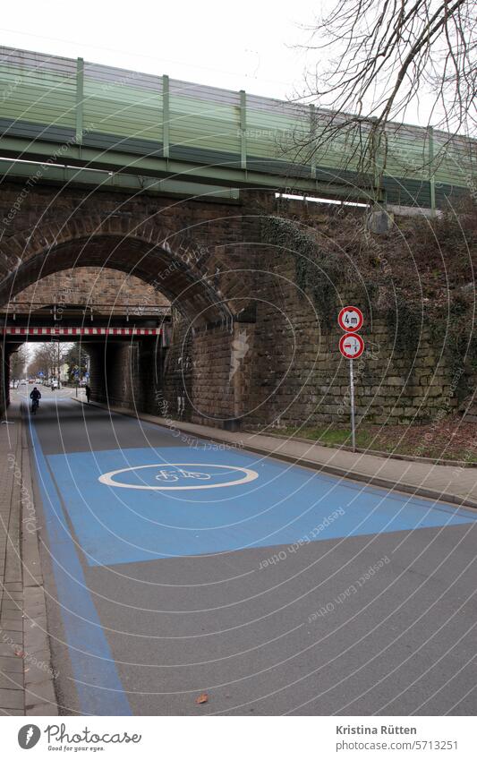 bicycle lane with cyclist under railroad bridge bicycle road Bridge Underpass transfer Street cyclists Bicycle Cycling bicycle traffic Road sign painted on