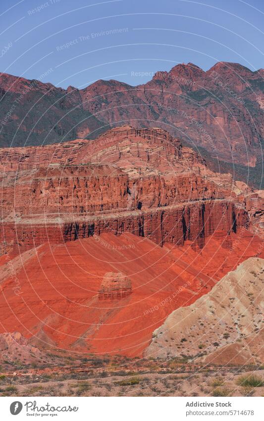 Layers of red and orange sedimentary rock formations stand out against the rugged backdrop of Los Castillos layer Argentina desert scenic nature geology outdoor