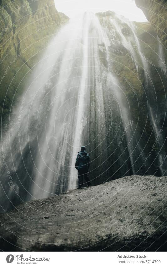 Man beholding the stunning Gljúfrabúi waterfall iceland gljúfrabúi man jacket blue nature travel majestic scenery adventure exploration outdoor destination