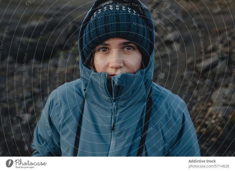 Woman dressed warmly against Icelandic backdrop iceland woman female travel adventure warm clothing jacket beanie outdoor serene gaze smile exploration tourist