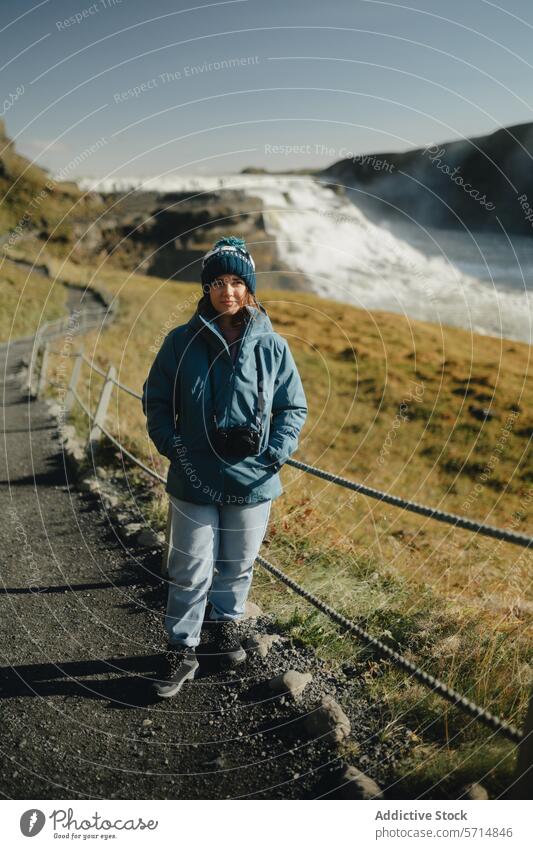 Female traveler at Gullfoss Waterfall in Iceland iceland gullfoss waterfall woman female outdoor path nature landscape mist tourist journey adventure