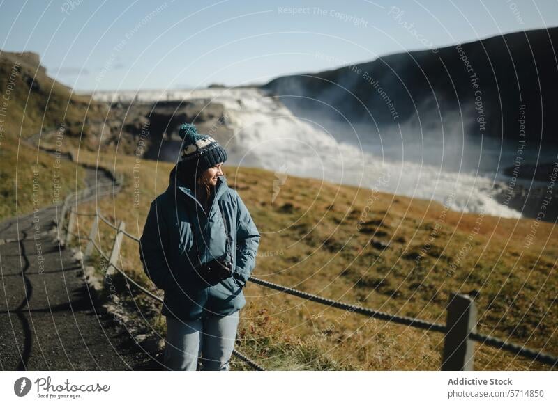 Woman enjoying the view at Gullfoss Waterfall, Iceland iceland woman tourist gullfoss waterfall travel female sightseeing nature landscape outdoor adventure