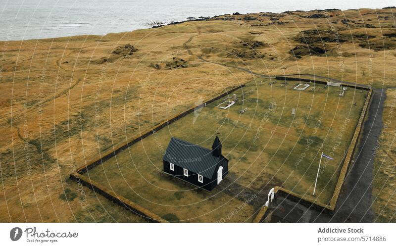 Solitary black church in the vast landscape of Iceland iceland búðakirkja aerial view ocean atlantic remote iconic landmark field barren nature travel solitude