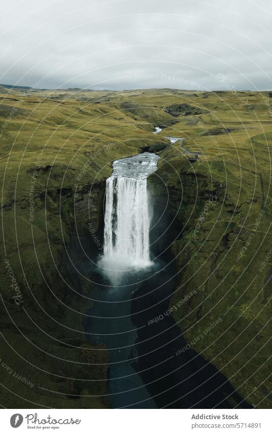 Majestic Waterfall in the Green Landscape of Iceland iceland waterfall landscape nature natural beauty green hills serene cascade pool verdant scenic isolated