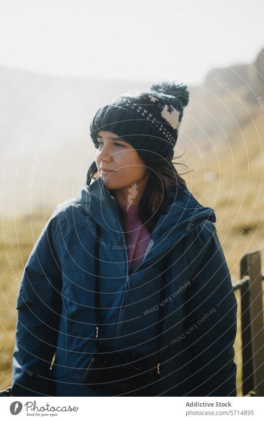 Contemplative woman in Iceland's serene landscape iceland female tranquil thoughtful contemplation winter hat highland daylight outdoors travel journey