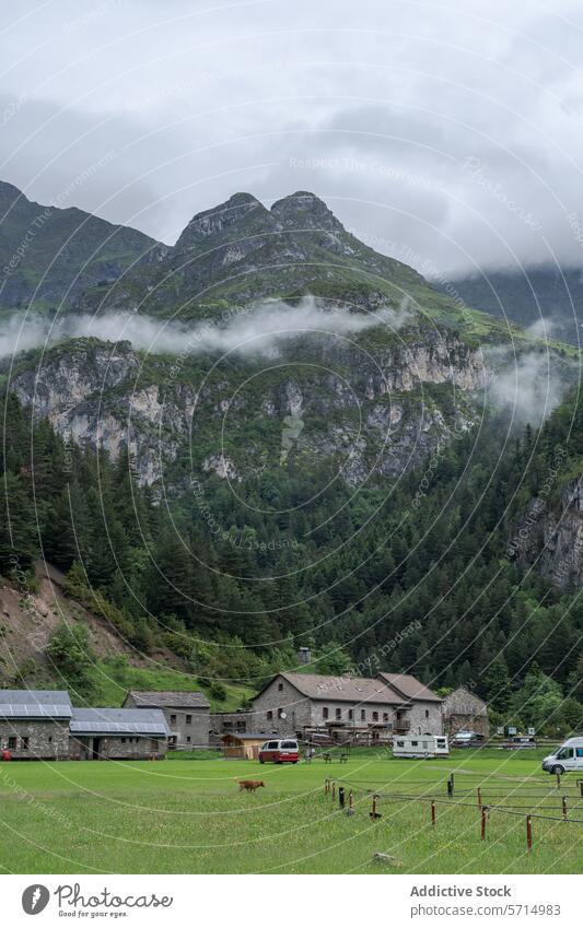 Misty Mountain Peaks Over Rustic Buildings in Bujaruelo Valley bujaruelo valley mountain mist building scenic view tranquil rustic ordesa monte perdido