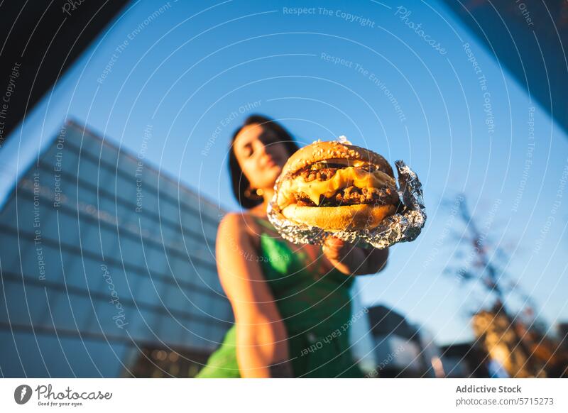 Urban food concept with woman holding burger in Madrid urban madrid spain four towers business area city life outdoor street food modern cuisine fast food snack