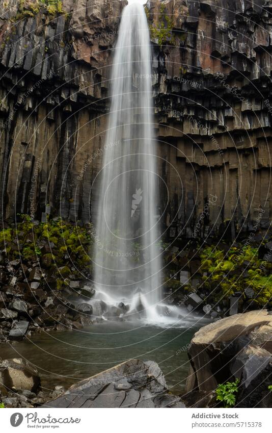 Majestic basalt column waterfall in Iceland iceland landscape nature serene cascade moss lush green rock flow geology basaltic columnar natural wonder feature