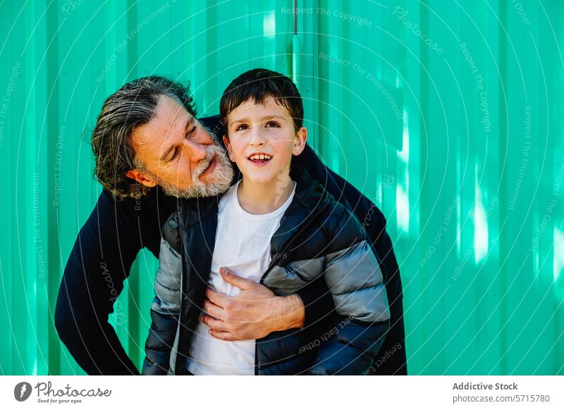 Tender moment between father and son against green background affection smile embrace heartwarming family love bonding parent child joyful togetherness