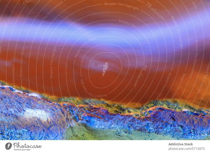 Abstract image of a colorful biofilm on ice at the edge of a pond, displaying a vibrant interplay of textures and colors Biofilm abstract close-up nature