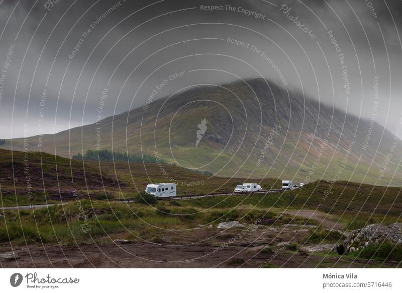 Motorhomes and caravans on the A82 road in the Glencoe mountains on a day with dramatic skies from the Glencoe lookout Glencoe view point scottish highlands