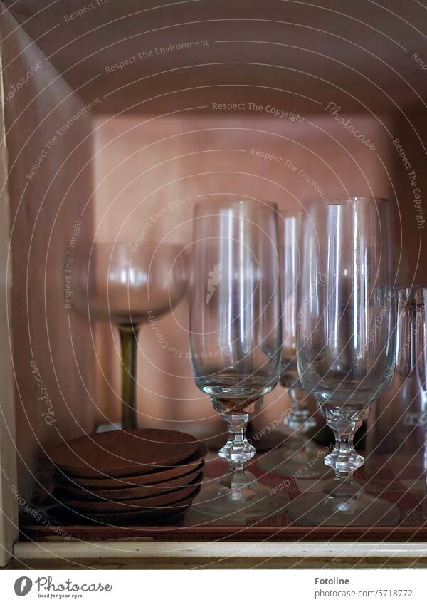 Tidy, but not clean, glasses and saucers stand in the cupboard of a long-abandoned lost place. Glasses Champagne glass Wine glass Coaster Crockery