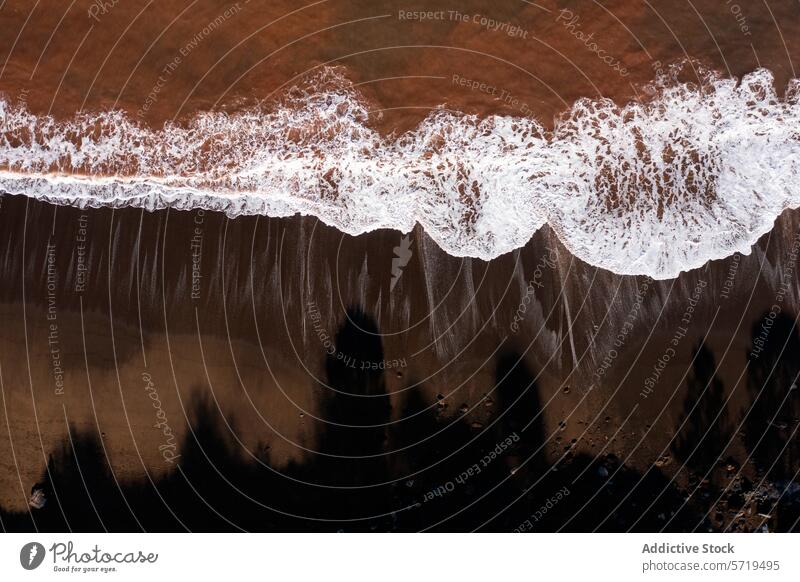 Rustic waves on Llumeres' reddish shore aerial view beach llumeres asturias water iron oxide mining historic shoreline foam ocean texture nature landscape coast