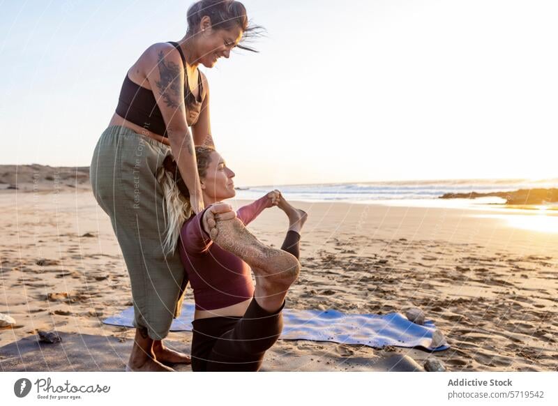 Yoga Practice at Sunset on the Beach yoga sunset beach practice assistance natarajasana pose relaxation fitness wellness health exercise nature sand sea