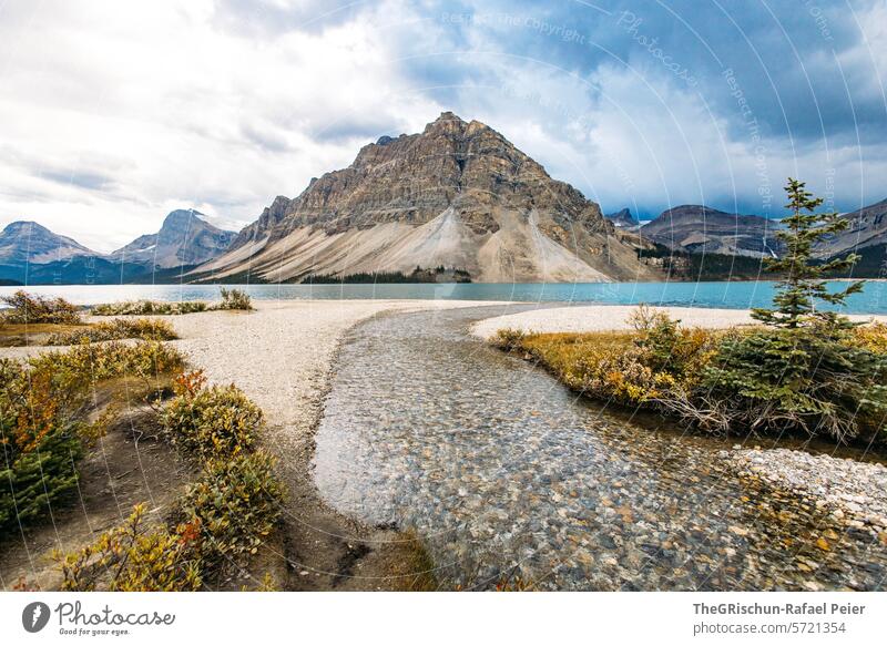 River flows into lake in front of mountains Canada Mountain Clouds Water Icefield parkway Rocky Mountains Vacation & Travel Exterior shot Colour photo Tourism