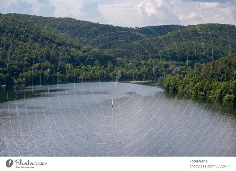 View of the Lake Edersee with a sailboat nature water Germany day lake Sailing Boat trees sky Ederstausee Europe view copy space landscape season reservoir