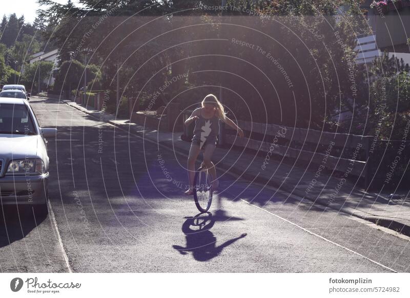 Girls riding unicycles Unicycle Ride a unicycle Street Child Summer game free time holidays residential area Residential area Sports urban Town Outdoors