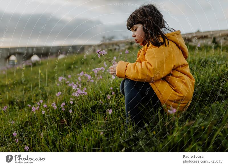 Cute girl with Yellow jacket picking flowers Girl 6 to 7 years Child Authentic child Colour Image Photo Photos children Color 6-7 persons kid kids Photography