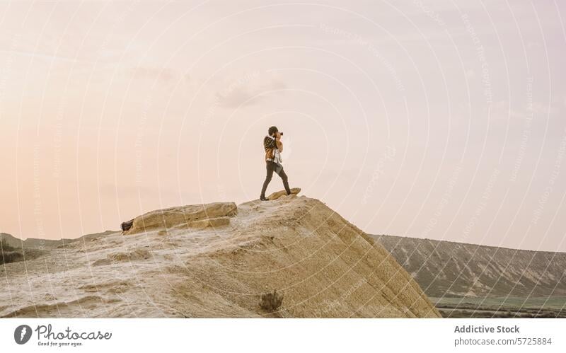 Hiker standing on cliff at Bardenas Reales at sunset hiker bardenas reales solitude spain navarra outdoor adventure travel landscape serene beauty nature