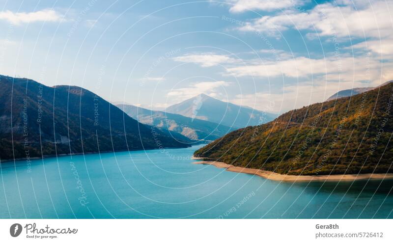 autumn landscape of mountains and lake in Georgia Caucasus background blue bright calm climate autumn clouds color day fog forest green haze hill holiday