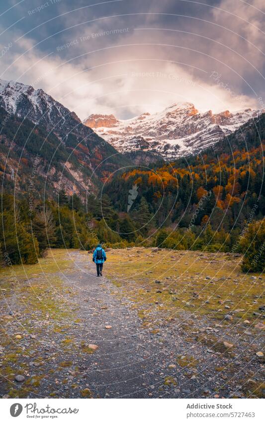 Lone hiker exploring snowy peaks in Bujaruelo Valley bujaruelo valley ordesa pyrenees autumn snow-capped mountain adventure solo travel trek path nature scenic