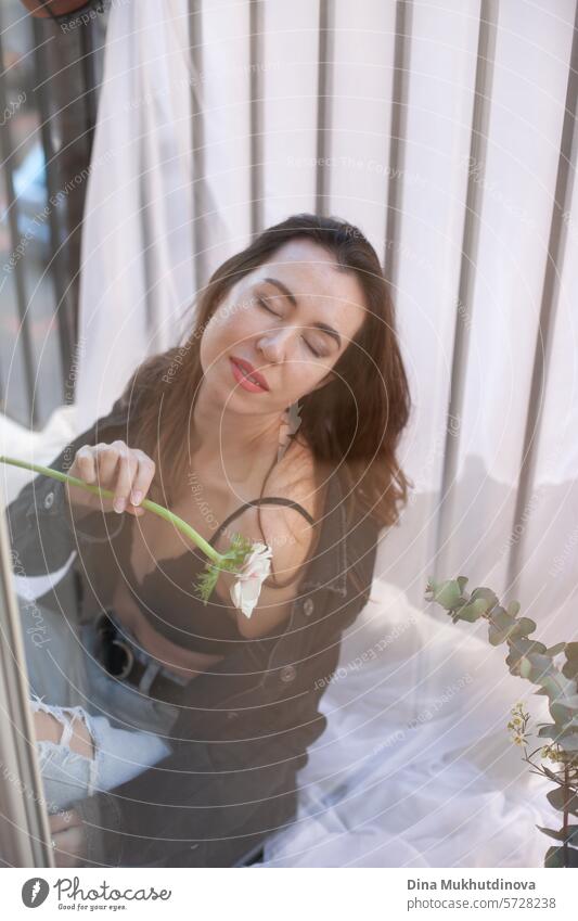 beautiful woman in grunge outfit with white flower sitting on the balcony of apartment 25 to 30 years Young woman Grunge grunge look Clothing outfits female