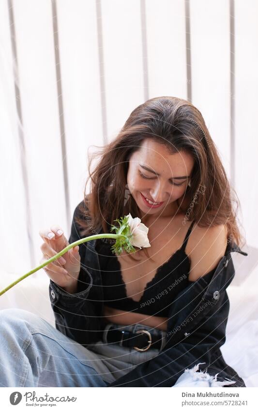 beautiful woman smiling in grunge outfit with white flower sitting on the balcony of apartment 25 to 30 years Young woman Grunge grunge look Clothing outfits