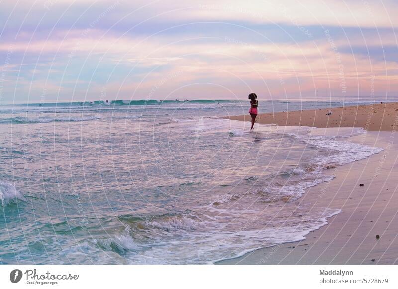 woman running on a beach during a beautiful  sunset Sunset Ocean Sand Vacation & Travel vacation Waves Nature Coast Sky Relaxation Beach Water Summer