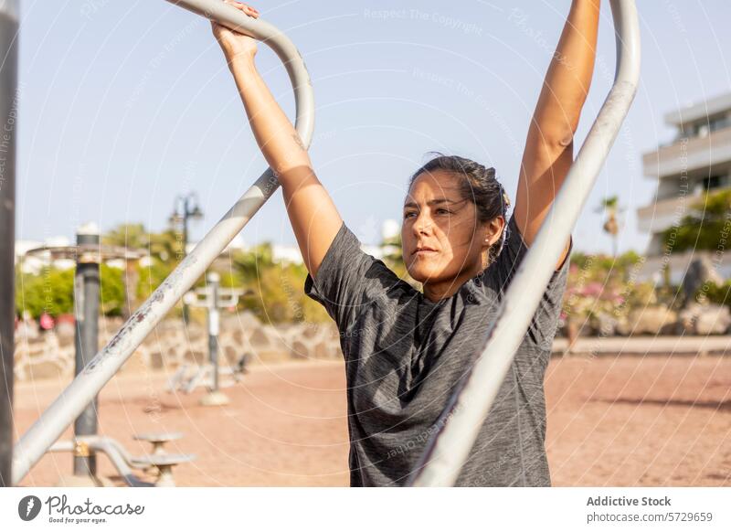 Woman exercising at beach side outdoor gym woman exercise workout fitness sunny day training health wellness active lifestyle sportswear physical activity