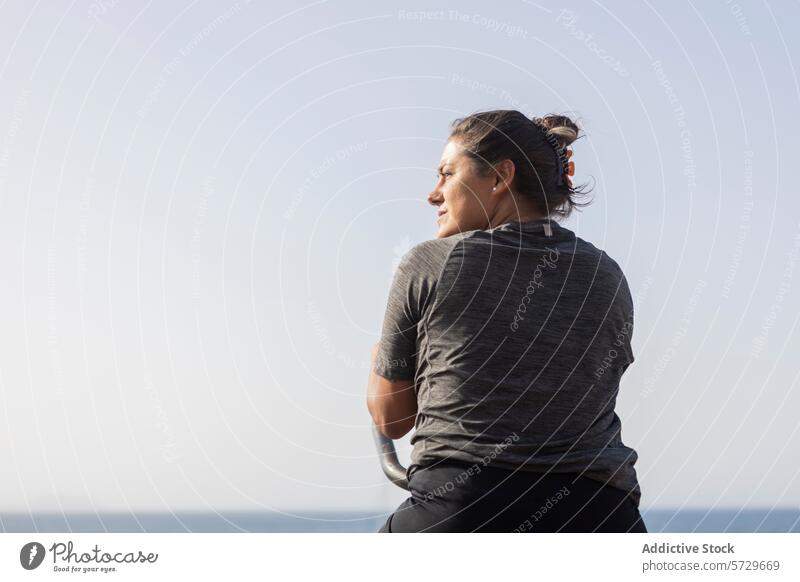 Woman at outdoor beach gym enjoying the sea view woman exercise fitness health equipment public sky horizon waterfront leisure lifestyle active wellness workout