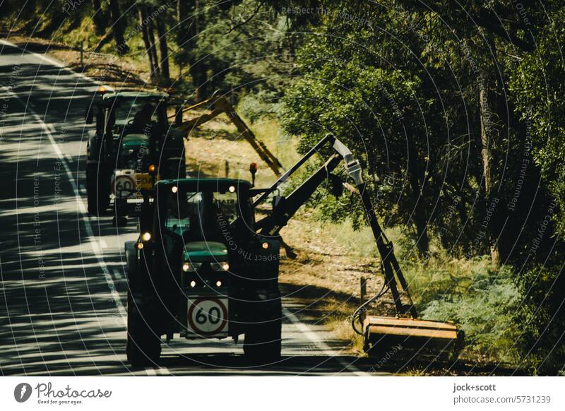 Tractors with mowers working on the roadside Street Sunlight Shadow road trip two lanes Median strip In transit Road movie Country road Traffic infrastructure