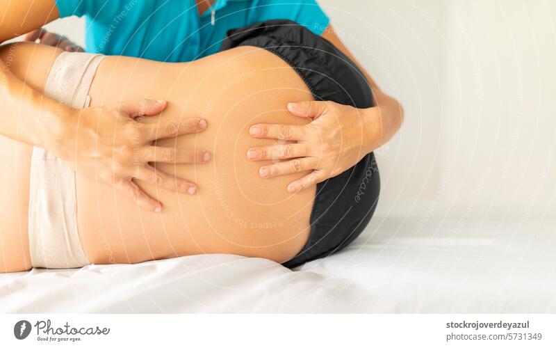 A female physical therapist performs a stretching and pressure exercise on her patient's lower back physiotherapist clinic rehabilitation health care