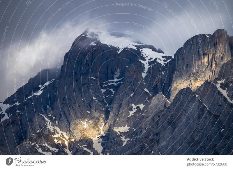 Majestic peaks of Picos de Europa under moody skies picos de europa snow rugged terrain cloud sunlit mountaintop national park spain nature landscape outdoors