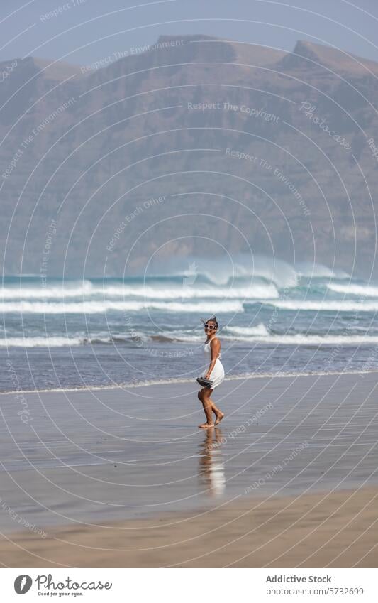 Woman enjoying a peaceful walk on a beach woman ocean mountain serene weekend getaway leisure sandy waves rugged backdrop solo coastline nature outdoor