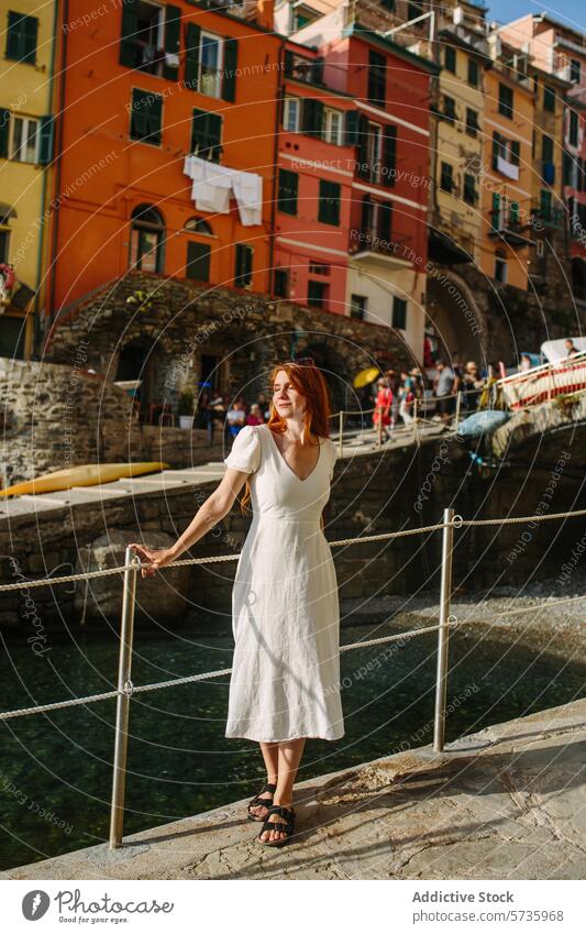 Elegant woman enjoying scenic coastal village dress white serene tranquil leisure travel vacation destination picturesque colorful architecture cultural