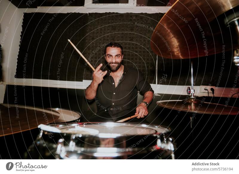 Smiling drummer with drumsticks in band rehearsal studio man music drum set smile looking at camera male instrument music equipment performance practice