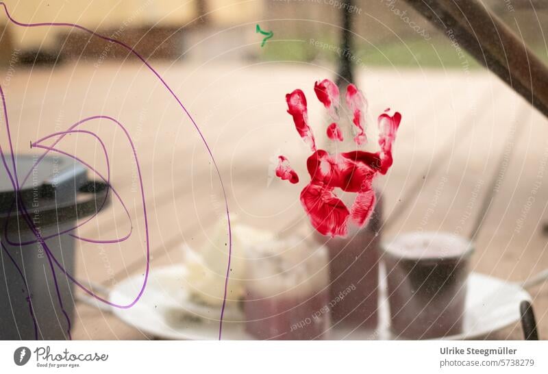 A red handprint of a child at the window Life with children Playing fun Finder color Hand variegated colorful hand boundless Free Study Creativity