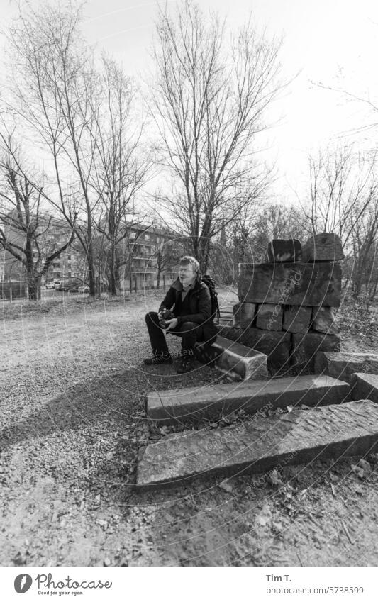 Park at Nordbahnhof with man Berlin northern railway station b/w Man Eyeglasses stones Winter