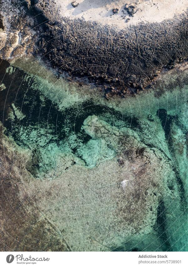 Aerial view of crystal clear waters and rocky shore aerial coastline serene beauty overhead shot translucent rugged shadow human presence ocean sea nature