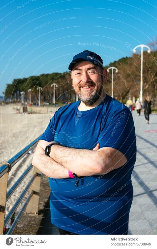 Smiling man enjoying sunny beach day in sportswear beard happy outdoor leisure casual relaxation sea sand lifestyle adult male nature coastline shore seaside