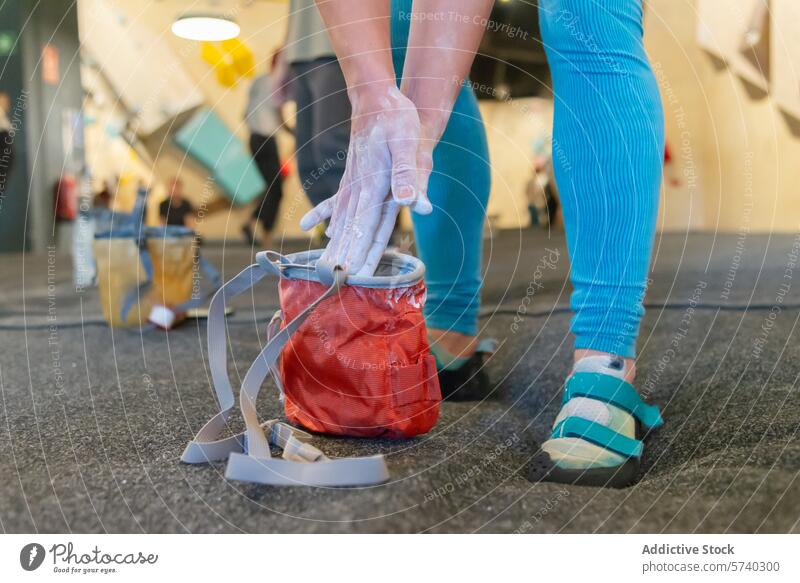 Preparing for Indoor Rock Climbing Adventure climber chalk hands preparation indoor rock climbing adventure red chalk bag gym blurred background activity sport