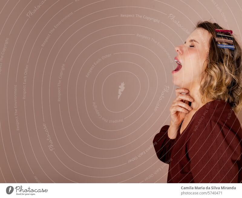 Young woman yawning with various hair accessories. Photo in studio with isolated background. Mental health. beautiful beauty body breakfast caffeine clean clear