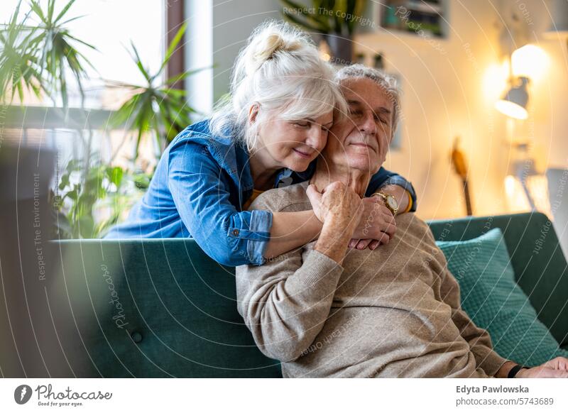 Portrait of a happy senior couple sitting on sofa at home people caucasian grey hair casual day portrait indoors real people white people adult mature retired