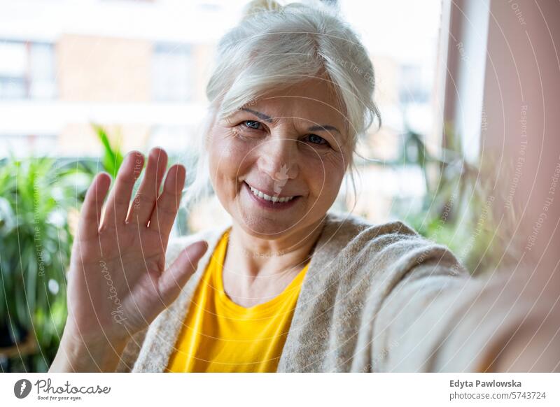 Portrait of smiling senior woman taking selfie at home people casual day portrait indoors real people white people adult mature retired old one person lifestyle