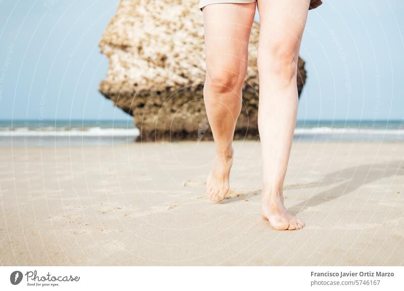 Legs of a woman walking on the sand on the beach of Matalasca?as, Huelva, Andalusia, Spain. person sea summer vacation water outdoor ocean nature lifestyle girl