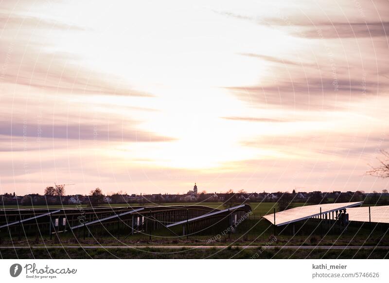 Solar park - photovoltaics on an open space at sunset against a village backdrop Solar Energy solar park Sunset Skyline green energy Solar system