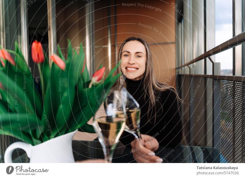 Young woman checking with boyfriend while sitting at table with bouquet of flowers on date young couple love romance relationship intimate together dining